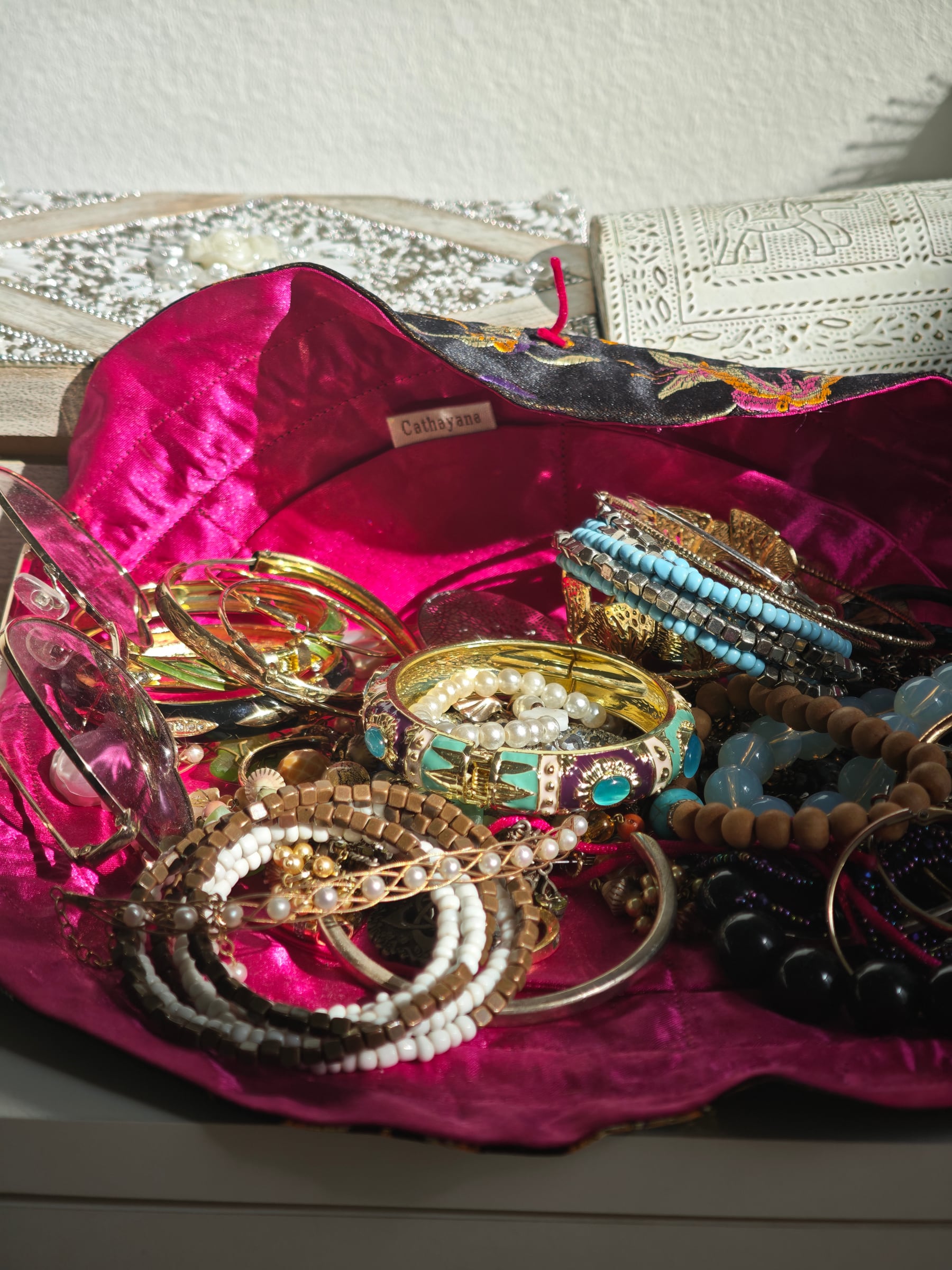 Gold, turquoise and pearl jewelry gathered on vivid silk